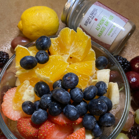 Bowl of savory fruit salad with orange segments, blueberries, strawberries, grapes, and banana pieces. Photo by Burlap & Barrel
