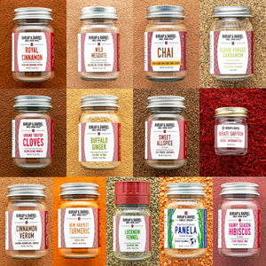 Collection of 13 Burlap & Barrel spice jars on a textured brown background