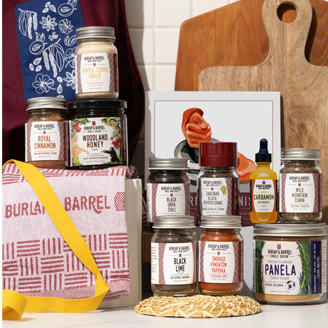 Collection of Burlap & Barrel products including jars and a bag on a wooden surface.