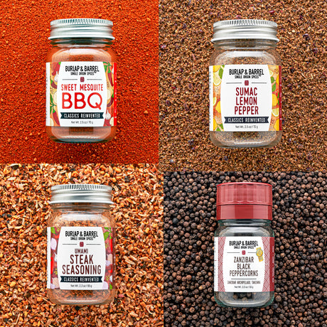Four jars of Burlap & Barrel spices on a textured background