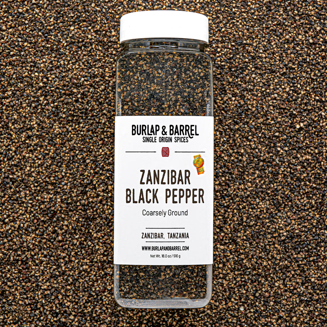 Bottle of Burlap & Barrel Zanzibar Black Pepper on a textured black and brown background
