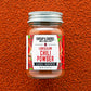 Jar of Burlap & Barrel Low & Slow Chili Powder on a textured brown background