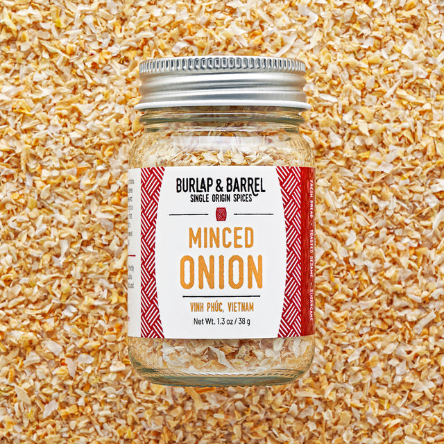 Jar of minced onion spice with 'Burlap & Barrel' label on a textured background