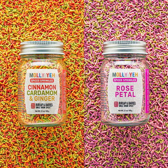 Two jars of Molly Yeh spiced sprinkles on a colorful sprinkle background.