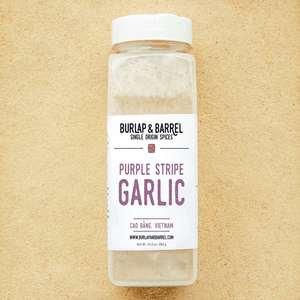 Bottle of Burlap & Barrel Purple Stripe Garlic on a beige background