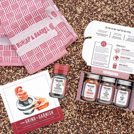 Spice set with jars, a towel, and recipe cards on a textured surface