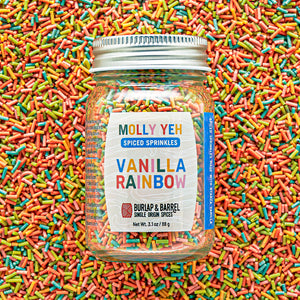 Jar of Molly Yeh & Burlap & Barrel Spiced Sprinkles with colorful sprinkles in the background