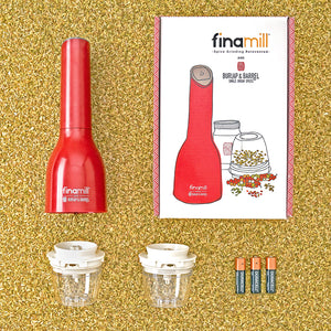 Finamill automatic grinder with the box it comes in, two removable grinding pods and 3 batteries on a bed of loose fennel seeds